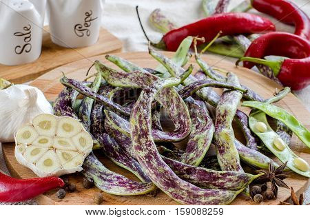 Pods Spotted Beans And Organic Vegetables And Spices On Wooden Board.
