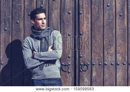 Handsome Man Wearing Winter Clothes In Wooden Background.