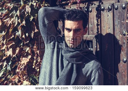 Handsome Man Wearing Winter Clothes In Wooden Background.