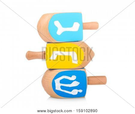 Wooden dreidels for Hanukkah on white background