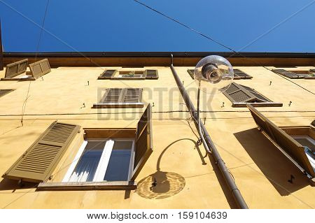 street lamp from the bottom with background the facade of the building in perspective.