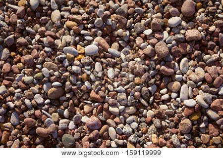 marine pebbles on the shore of the Baltic Sea, to grind with water in various sizes and colors, the oval and round,  nature, background tinted, preset, yellow tint