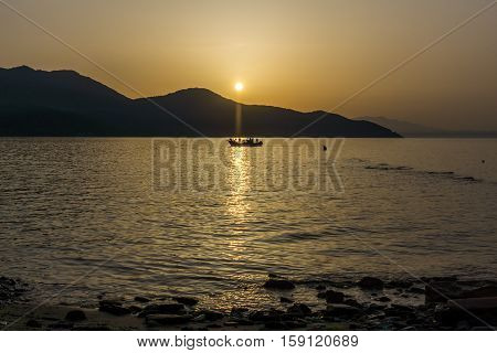 Amazing Sunset seascape with old boat in the sea of Thassos town, East Macedonia and Thrace, Greece