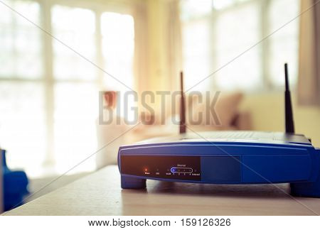 closeup of a wireless router and a young man using Laptop and notebook computers on living room at home with a window in the background
