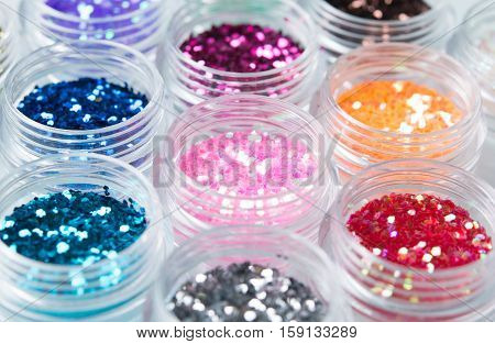 glitter for nail decoration on the white bacground