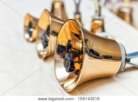 Set of gold handbells on table during concert. Christmas time