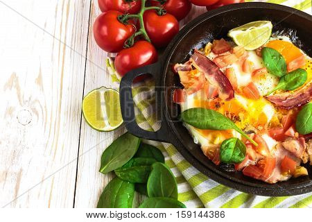 Pan Of Fried Eggs With Tomatoes, Bacon, Spinach, Lime