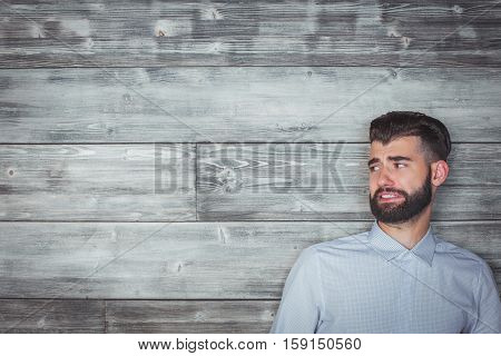Portrait of handsome caucasian man with funny expression on wooden wall background. Emotion concept