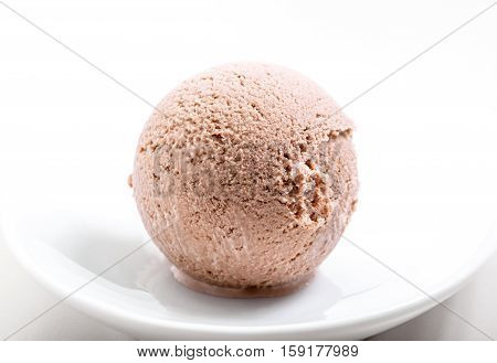 chocolate ice cream scoop on white plate close-up