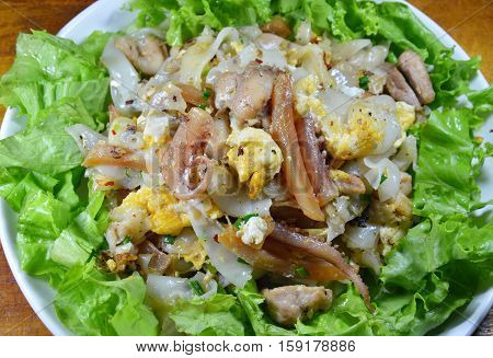 stir fried rice noodle with chicken and crispy pickled squid on dish