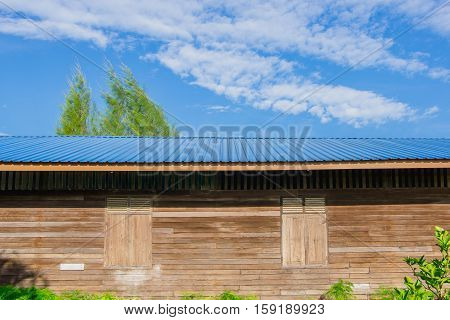 The old wooden building roofed with blue sheet metal roofs and sky background.