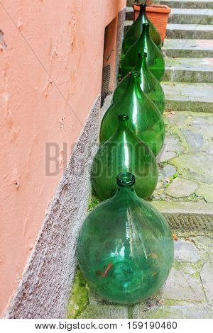Row Of Demijohns In An Italian Village