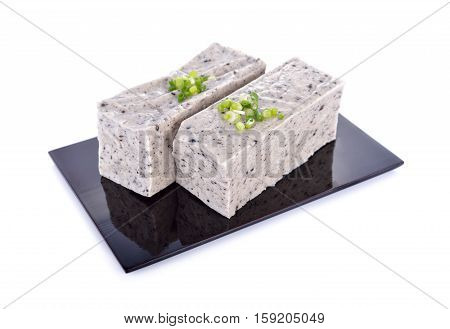 tofu mix black sesame seeds on black plate with white background