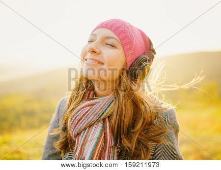 Young Beautiful Woman Smiling And Enjoying Music In Fall Season