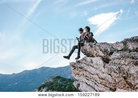 Man And Women Using Phone In Mountain In Montenegro, Freedom And Travel Cocept