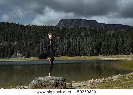 Man Practicing Yoga Near The Autumn Black Lake, Durmitor National Park, Zabljak, Montenegro. Spiritu
