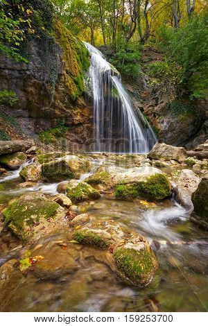 Beautiful autumn landscape with waterfall and stones