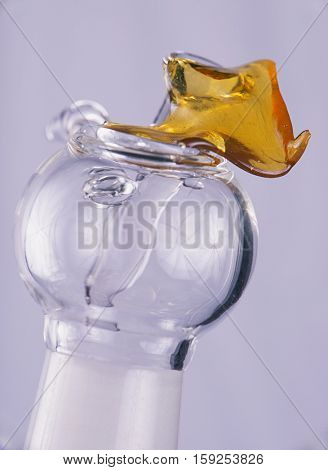 Close up view of a piece of cannabis oil concentrate aka shatter with glass rig bowl and nail isolated on white