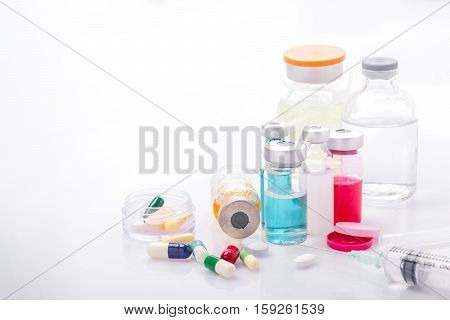 Glass Medicine Vials with syringe pills capsule on white table
