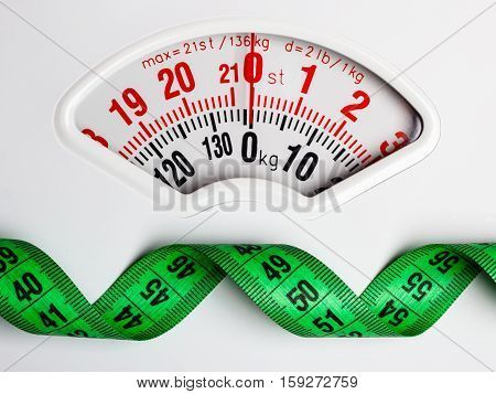 Green Measuring Tape On Weight Scale. Dieting