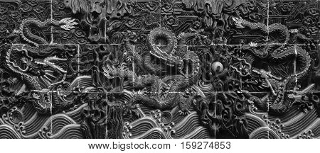 TILES OF DRAGON SCULPTURES ON THE WALL