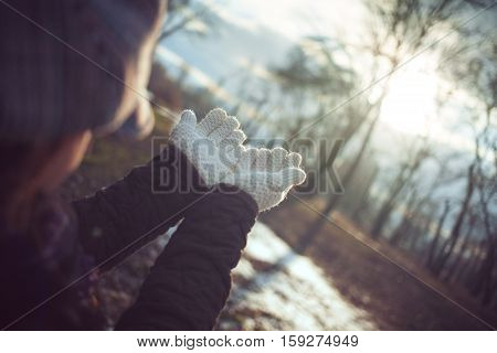 Young girl spreading hands with joy and inspiration facing the sun