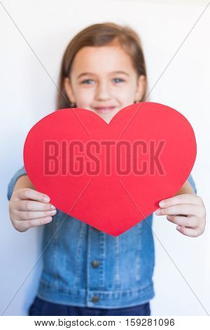 Happy Six-Year Girl Hold Big Red Heart On White Background. / Little Girl Give Red Heart For Valentine's Day. Selective Focus.