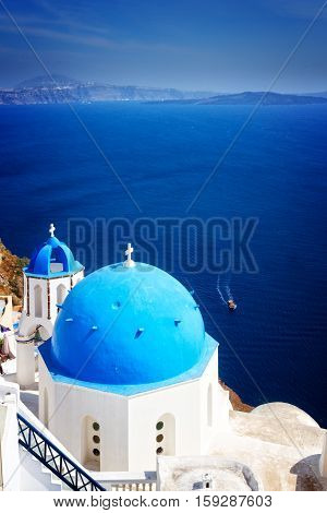 traditional blue dome of church with bellfry against blue sea, Oia, Santorini, retro toned