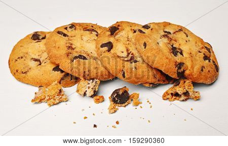 Tasty cookies with chocolate chips and crumbs on white background