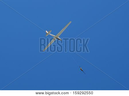 propeller-driven airplane is towing a glider in the sky
