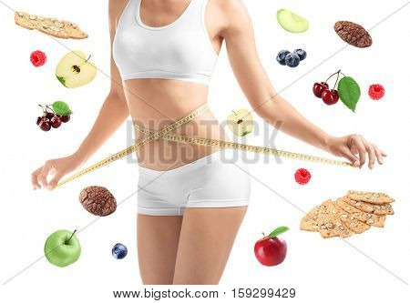 Woman with measuring tape around waist and healthy food on white background. Diet and fitness concept.