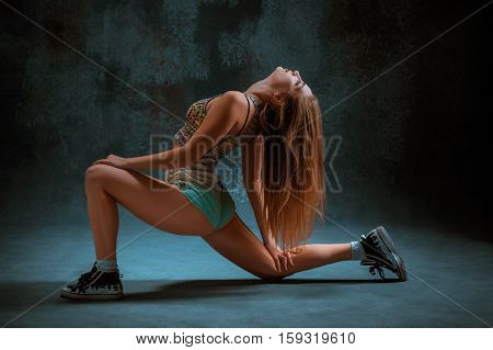 Attractive girl dancing twerk iat the blue studio background