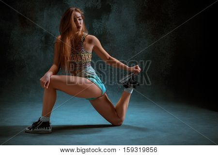 Attractive girl dancing twerk iat the blue studio background