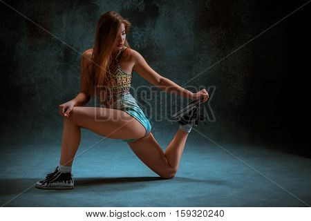 Attractive girl dancing twerk iat the blue studio background