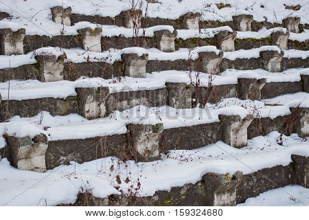 Benches under snow in an abandoned stadium in the daytime