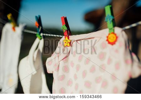 baby clothes drying on a rope in the woods