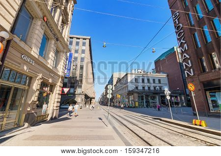 Helsinki Finland - June 24: People walking on a sunny day in a typical street at the centre of Helsinki on June 24 2013. There are some famous shops and stores in this street.