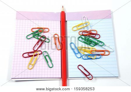 Colorful paperclips, notebook and red wooden pencil
