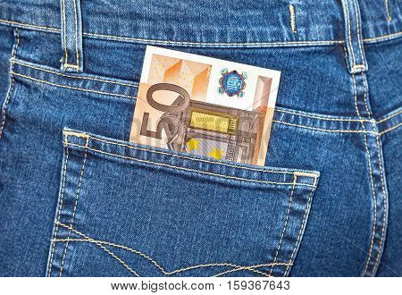 Banknote 50 euro sticking out of the blue jeans pocket. Money for travel and shopping