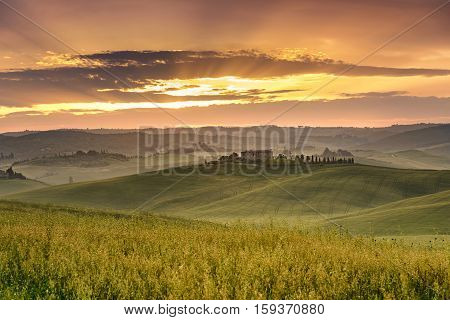 typical Tuscan landscape with rolling hills at the sunset
