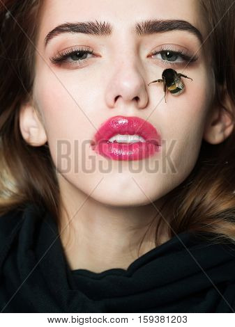 Pretty girl cute sexy young beautiful woman brunette female model with sexi pink lips and humblebee bee on face