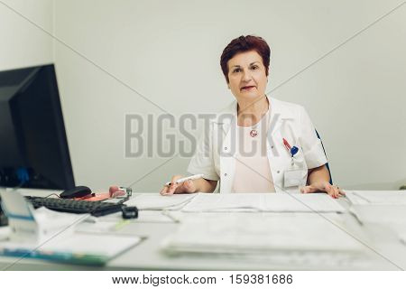 Taking care of your health concept. Experienced doctor prescribing medicines. Senior medical professional writing patients medical record. Retiring doctor.Retirement