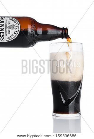 LONDON UK - NOVEMBER 29 2016: Guinness extra stout beer bottle on white background. Guinness beer has been produced since 1759 in Dublin Ireland.