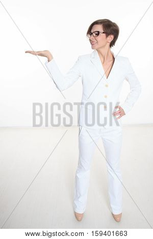 Young attractive businesswoman. Isolated on white. She is holding her hand raised. Isolated on white background.