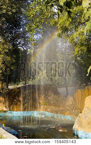Rainbow in the drops of fountain in pool in nehru park, delhi