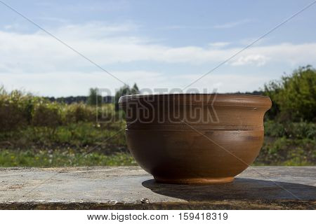 Brown ceramic pot on a background of the rural landscape
