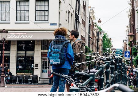 Amsterdam Netherlands - August 2 2016: Travelers in the street in historical city center of Amsterdam. It is one of the most romantic and beautiful cities in Europe. Amsterdam is also a city of tolerance and diversity.