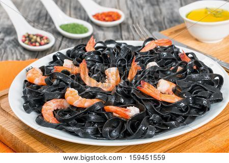 Squid Ink Black Noodles With King Prawns On White Dish