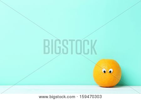 Ripe Orange With Googly Eyes On Green Background