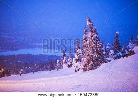 Beautiful cold mountain view of ski resort, winter day with slope, piste and ski lift, evening twilight night picture